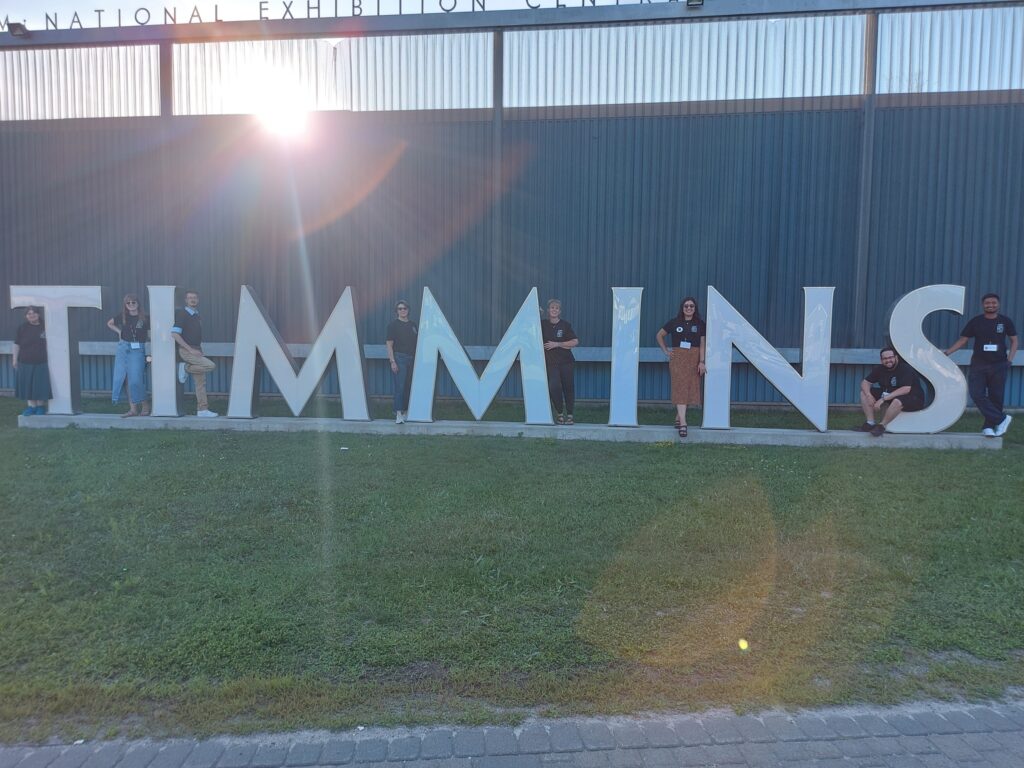 Staff at the Timmins Museum outside with the Timmins sign