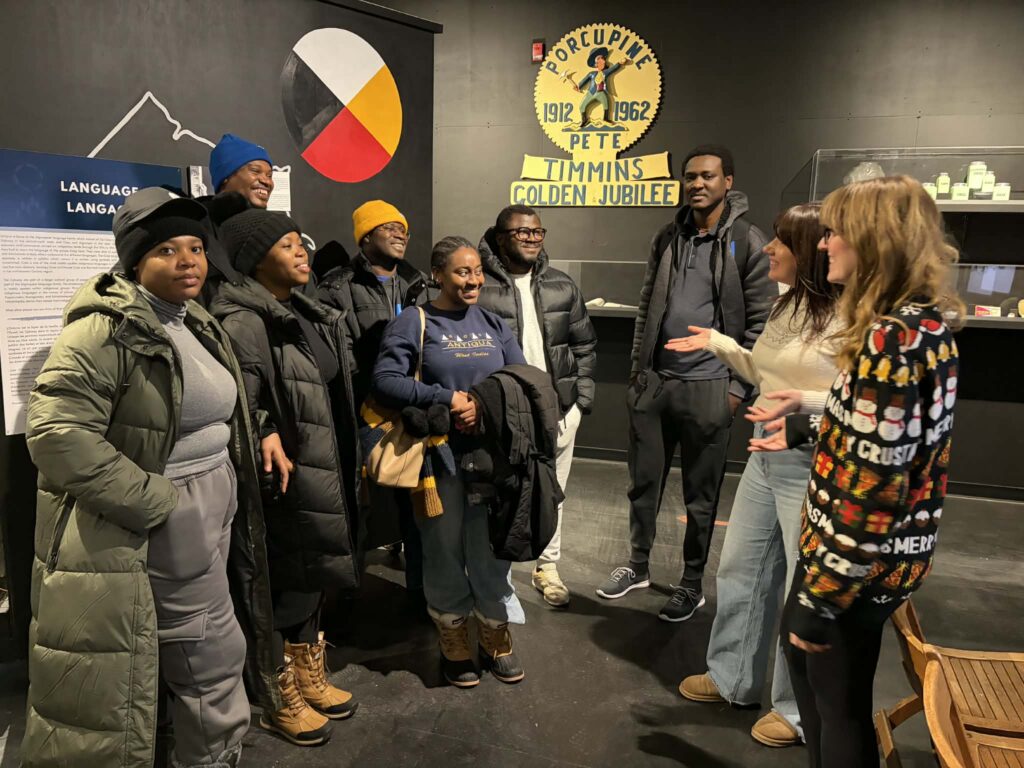 A group tour listens to an explanation about an exhibit